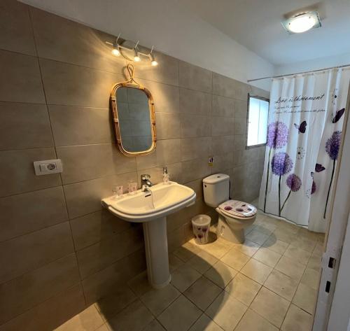 a bathroom with a sink and a toilet and a mirror at Villa Estrella Polar in Tahiche