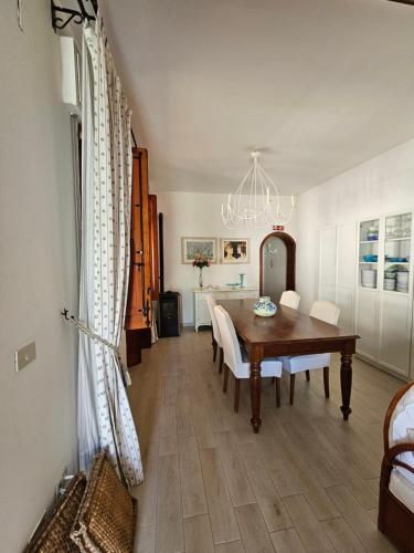 a dining room with a table and chairs and a chandelier at IsolaHome in Isola delle Femmine