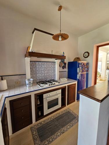 a kitchen with a stove and a counter top at IsolaHome in Isola delle Femmine