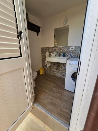 a bathroom with a toilet and a sink and a washing machine at IsolaHome in Isola delle Femmine