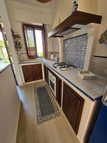 a kitchen with a stove and a counter top at IsolaHome in Isola delle Femmine