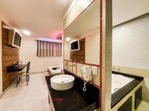 a bathroom with a tub and a toilet and a sink at Red Rose Motel & hotel in Franco da Rocha