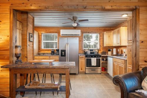 a kitchen with wooden cabinets and a refrigerator at Misty Mountain Cabin Spectacular Scenic Escape by Caddo River in Glenwood