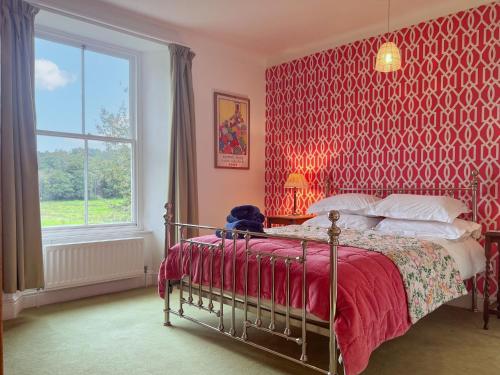 a bedroom with a bed with a red wallpaper at Little Parrock, Grasmere in Grasmere