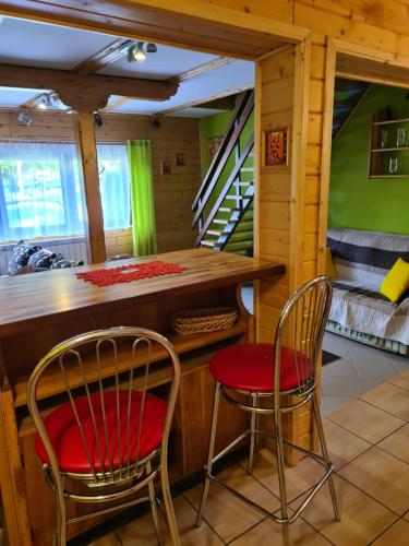 a kitchen with two chairs and a bar in a cabin at Domek Domino in Korbielów