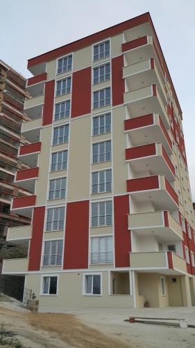 een hoog gebouw met rood en wit bij اجنحة الراحة للشقق الفندقية Comfort Suites in Komera
