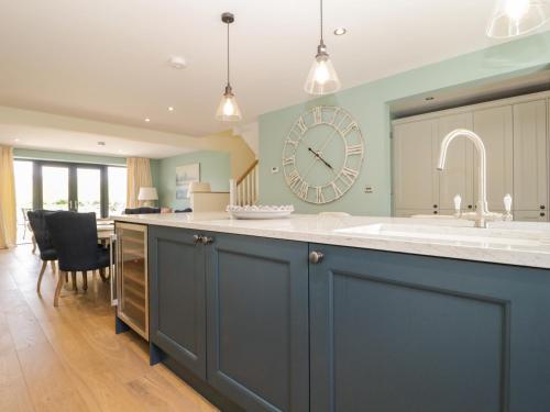 a kitchen with a large clock on the wall at Tarn End Cottages 12 in Brampton