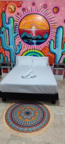 a bed in front of a wall with a mural at Garden House Puerto López in Puerto López