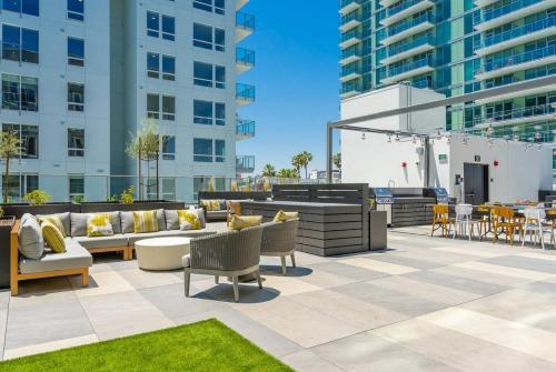 a patio with couches and chairs and tables and buildings at Level Long Beach - East Village in Long Beach