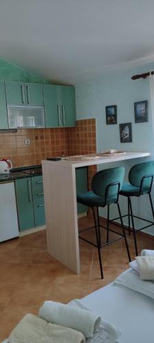 a kitchen with green cabinets and a table and chairs at Sea and Sunshine in Tivat