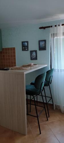a kitchen with two green chairs and a counter at Sea and Sunshine in Tivat