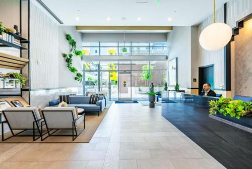 a woman sits in the lobby of a building at Level Long Beach - East Village in Long Beach