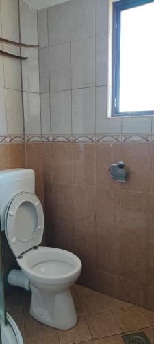 a bathroom with a white toilet and a window at Sea and Sunshine in Tivat
