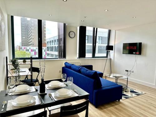 a living room with a blue couch and a table at Luxury 1 Bedroom Apartment in Old Trafford in Manchester