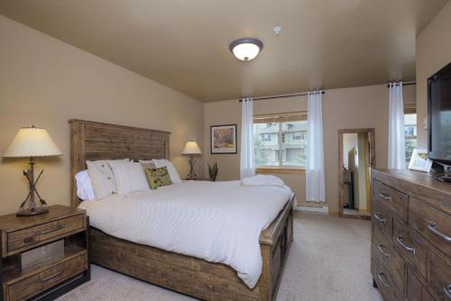a bedroom with a large bed and a television at Deer Run Condo - 12 Blacktail Buck in Big Sky