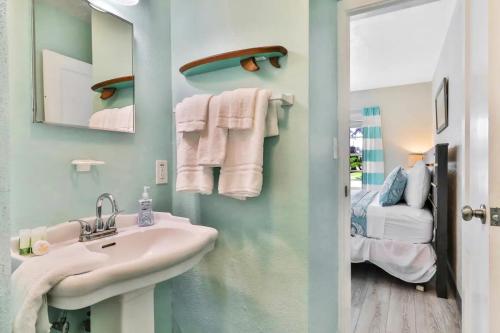 a bathroom with a sink and a mirror and a bed at Pelican Beach Studio #6 in Clearwater Beach