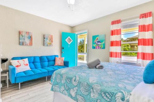 - une chambre avec un lit bleu et un canapé bleu dans l'établissement Pelican Beach Studio #6, à Clearwater Beach