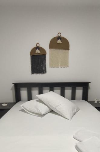 a bed with a white pillow and two mirrors on the wall at Eva tatil evleri in Perşembe
