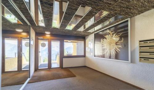 a living room with a ceiling with windows at Auris les Gentianes station Alpe Huez in Auris