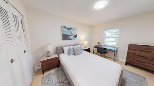 - une chambre blanche avec un grand lit et un bureau dans l'établissement Furnished Apartment, Free Parking, Pool Gym Pb, à Newark