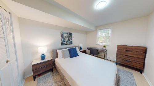 ein Schlafzimmer mit einem Bett, einer Kommode und einem Fenster in der Unterkunft Furnished Garden Style Apt, Pool Gym Parking Pb in Newark