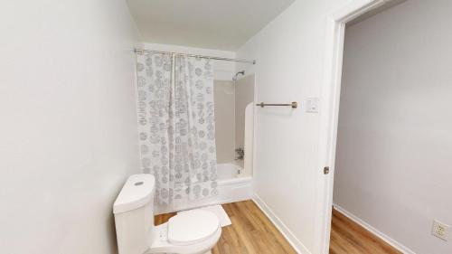 uma casa de banho branca com um WC e um chuveiro em Charming Furnished 2br With Parking, Gym, Pb em Newark
