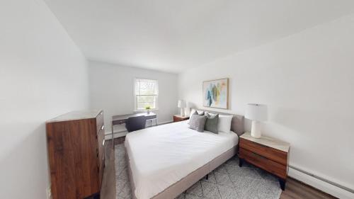 um quarto branco com uma cama grande e uma janela em Charming Furnished 2br With Parking, Gym, Pb em Newark