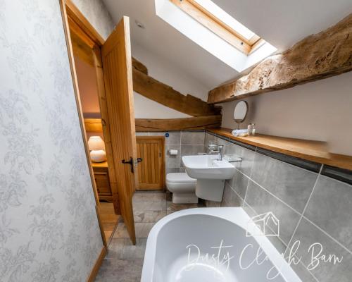a bathroom with a white toilet and a sink at Dusty Clough Barn in Preston