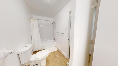 a white bathroom with a toilet and a shower at Furnished 2br Pool Gym Parking Pb in Newark