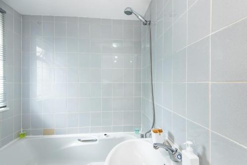 y baño con bañera y lavamanos. en Spacious en-suite in a 5-Bedroom House at Hanwell (2nd Floor), en Hanwell