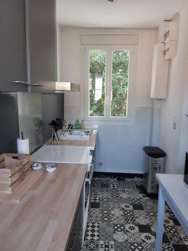 une cuisine avec un comptoir et une fenêtre. dans l'établissement ARCACHON CENTRE 6 mn de la plage à pied 4 chambres 8 couch, à Arcachon