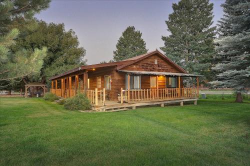 eine Blockhütte mit einer großen Veranda im Hof in der Unterkunft Vista Court Cabins & Lodge in Buena Vista