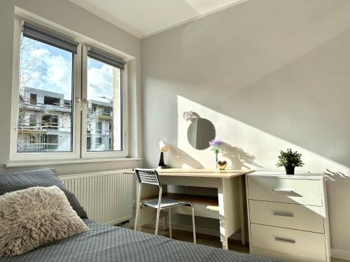 een slaapkamer met een bureau, een bed en een raam bij MMRent Bubble Room in Gdańsk