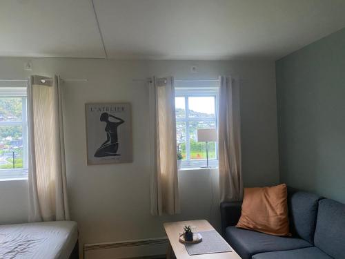 Habitación con cama, sofá y ventana en Nyoppusset leilighet en Sogndal