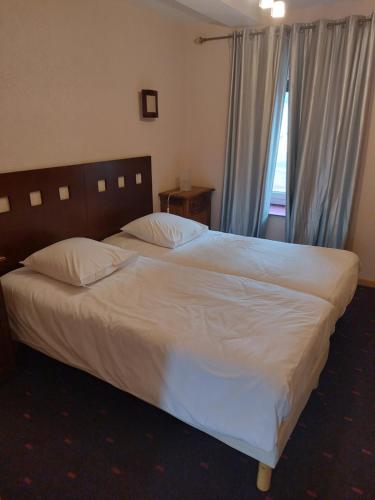ein Schlafzimmer mit einem großen weißen Bett und einem Fenster in der Unterkunft La Table du Pic in Montverdun