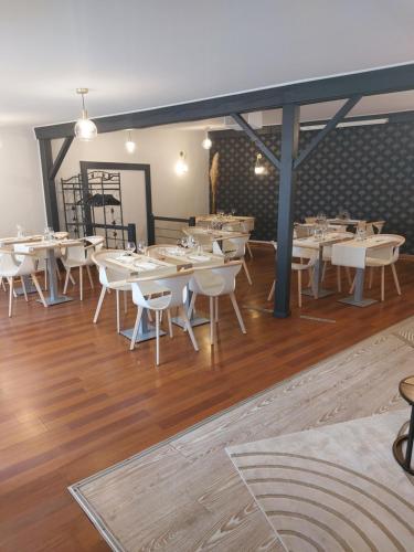 une salle à manger avec des tables et des chaises blanches dans l'établissement La Table du Pic, à Montverdun