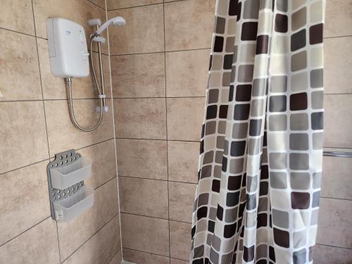 a shower with a black and white shower curtain at Double room in Stone in Kent