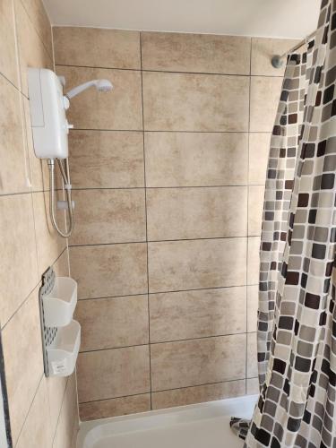 a bathroom with a shower and a tub at Double room in Stone in Kent