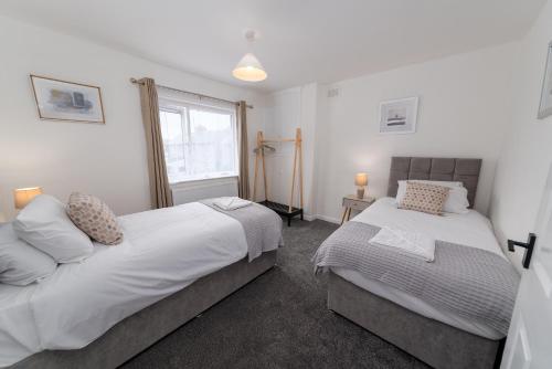a bedroom with two beds and a window at Jesmond Square in Hartlepool