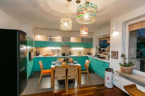 a kitchen with blue cabinets and a table with chairs at Stunning apartment. Garage. Security. Mokotów area in Warsaw