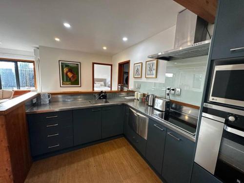 uma grande cozinha com armários azuis e um lavatório em Woolshed 17 - Self Catering Accommodation em Havelock North