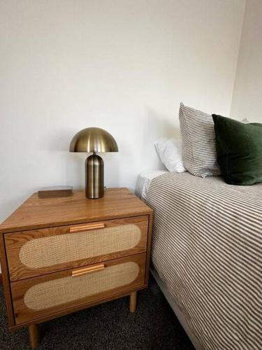 a bed and a nightstand with a lamp on top of a bed at Woolshed 17 - Self Catering Accommodation in Havelock North