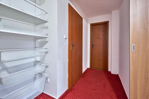 a walk in closet with a red carpet and a door at Apartmány Kateřina in Ricany