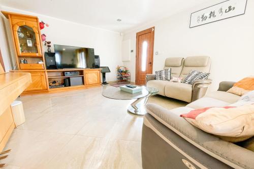 a living room with a couch and a tv at #FW The House of Sunny Gardens in Saint-Ismier