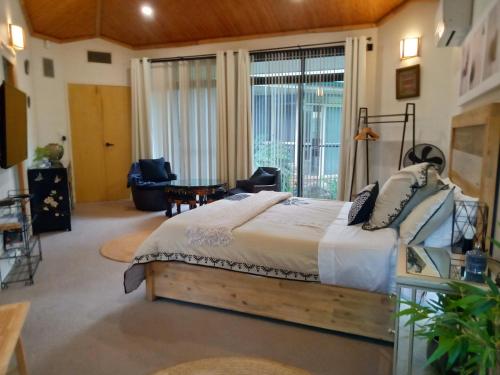a bedroom with a bed and a large window at Garden Apartment, self contained, Hunter Valley in Muswellbrook