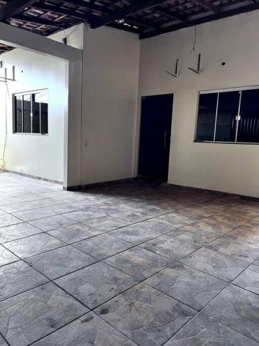 um quarto vazio com paredes brancas e piso em azulejo em Aluga-se casa mobiliada com wifi em Altamira