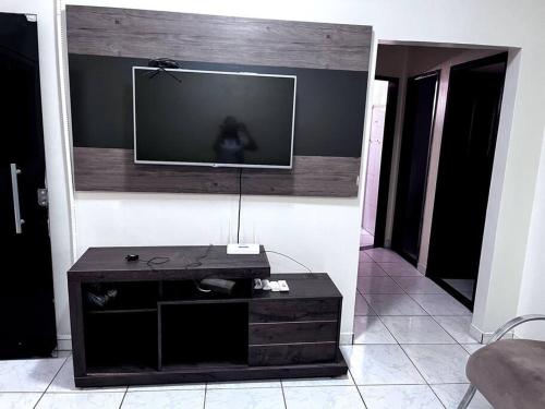 a living room with a television on a wall at Aluga-se casa mobiliada com wifi in Altamira