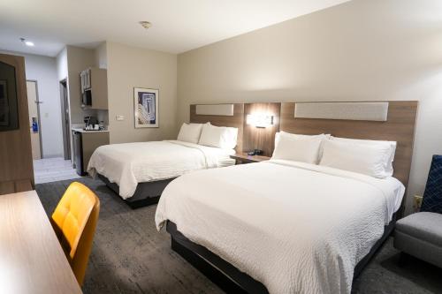 a hotel room with two beds and a chair at Holiday Inn Express Hotel & Suites Cedar Hill by IHG in Cedar Hill