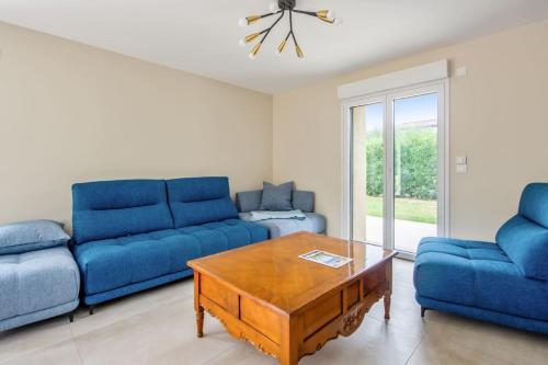 - un salon avec deux canapés bleus et une table basse dans l'établissement Villa Indigo - Welkeys, à Mandelieu-la-Napoule