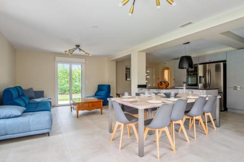 a dining room and living room with a table and chairs at Villa Indigo - Welkeys in Mandelieu-la-Napoule